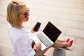 Businesswoman using laptop and mobile phone outside Royalty Free Stock Photo