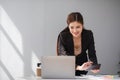 Businesswoman using laptop and mobile phone talking about work and managing company business Royalty Free Stock Photo