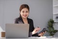 Businesswoman using laptop and mobile phone talking about work and managing company business Royalty Free Stock Photo