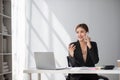Businesswoman using laptop and mobile phone talking about work and managing company business Royalty Free Stock Photo