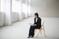 Businesswoman Using Laptop While Sitting On Chair In Warehouse Royalty Free Stock Photo