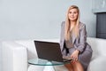 Businesswoman using laptop sitting on sofa at office Royalty Free Stock Photo