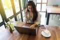 Businesswoman using laptop talking on cell phone.