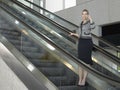 Businesswoman Using Mobile Phone On Escalator Royalty Free Stock Photo