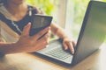 Businesswoman using mobile phone during video conversation in internet via net-book with staff during