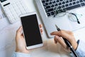 Businesswoman using mobile phone and working on Desk office with marketing graph statistics Royalty Free Stock Photo