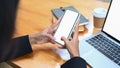 Businesswoman using mobile phone and working with laptop at office desk. Royalty Free Stock Photo