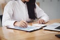 A businesswoman using pen point to chart document is researching earnings affected by the coronavirus pandemic to adjust