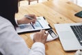 A businesswoman using pen point to chart document is researching earnings affected by the coronavirus pandemic to adjust