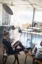 Businesswoman using phone while relaxing on chair at office Royalty Free Stock Photo