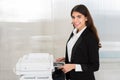 Businesswoman Using Photocopy Machine In Office Royalty Free Stock Photo