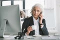 Businesswoman using smartphone and drinking coffee at workplace in office Royalty Free Stock Photo