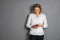 Businesswoman using smartphone on grey background Royalty Free Stock Photo