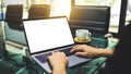 A businesswoman using and typing on laptop computer with blank white desktop screen in the office , coffee cup on Royalty Free Stock Photo