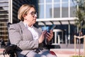 businesswoman using wheelchair typing on phone