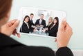 Businesswoman video conferencing with team on digital tablet