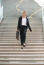 Businesswoman walking downstairs with briefcase Royalty Free Stock Photo