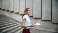 Businesswoman walking downstairs in city. Woman working with business papers Royalty Free Stock Photo