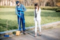 Businesswoman walking through the man sweeping in the park