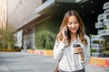 businesswoman walking outdoors talking on cell smart mobile phone and holding coffee cup takeaway Royalty Free Stock Photo