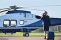 Rear View Of Businesswoman Walking Towards Helicopter Whilst Talking On Mobile Phone Royalty Free Stock Photo