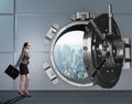 Businesswoman walking towards open vault door Royalty Free Stock Photo