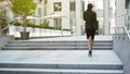 Businesswoman walking upstairs to building, moving up career ladder, success Royalty Free Stock Photo