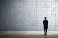 Businesswoman watching, big puzzle on wall, Woman looking at big puzzle, AI generated Royalty Free Stock Photo