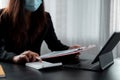 businesswoman wear mask working on desk office with using a calculator to calculate the numbers, finance accounting Royalty Free Stock Photo