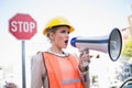 Businesswoman wearing builders clothes shouting in megaphone Royalty Free Stock Photo