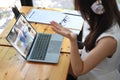 Businesswoman wearing headphones and having video conference with diverse colleagues  with laptop. Royalty Free Stock Photo