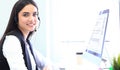 Businesswoman wearing microphone headset using computer in the office - operator, call center.