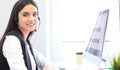 Businesswoman wearing microphone headset using computer in the office - operator, call center. Royalty Free Stock Photo