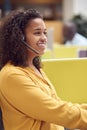 Businesswoman Wearing Phone Headset Talking To Caller In Busy Customer Services Centre Royalty Free Stock Photo