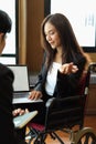 Businesswoman in wheelchair presenting her work on laptop to manager Royalty Free Stock Photo