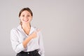 A businesswoman in a white shirt points her finger at a copy space for advertising on a gray background Royalty Free Stock Photo