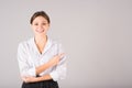 A businesswoman in a white shirt points her finger at a copy space for advertising on a gray background Royalty Free Stock Photo