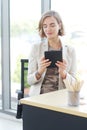 Businesswoman in white suit hand holding tablet for searching on website and thinking in job at workspace in office Royalty Free Stock Photo