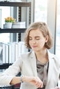 Businesswoman in white suit Watch wristwatch and serious about important Time for to late and delay