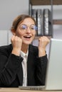 Businesswoman winner working browsing typing on laptop at office celebrate big lottery win good news Royalty Free Stock Photo