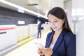 Businesswoman working on cellphone in train platform Royalty Free Stock Photo