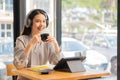 Businesswoman working in coffee shop remotely using and mobile tablet Royalty Free Stock Photo