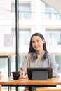 Businesswoman working in coffee shop remotely using and mobile tablet Royalty Free Stock Photo