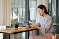 Businesswoman working in coffee shop remotely using and mobile tablet Royalty Free Stock Photo