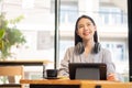 Businesswoman working in coffee shop remotely using and mobile tablet Royalty Free Stock Photo