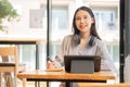 Businesswoman working in coffee shop remotely using and mobile tablet Royalty Free Stock Photo