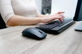 Businesswoman working on a computer from home during pandemic to prevent disease. Remote work. Selective focus. Hands, mouse, Royalty Free Stock Photo