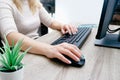 Businesswoman working on a computer from home during pandemic to prevent disease. Remote work. Selective focus. Hands, mouse, Royalty Free Stock Photo