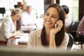 Businesswoman Working At Desk Using Mobile Phone