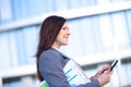 Businesswoman working on digital tablet outdoor over building background